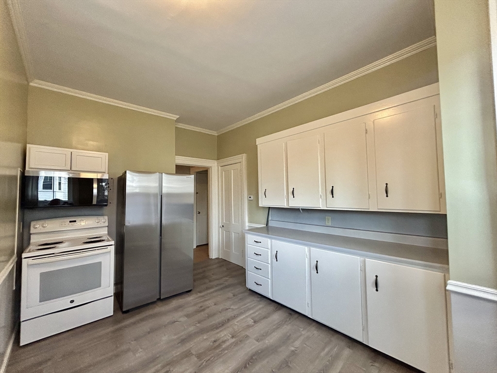 48 Congress Street Greenfield, MA 01301 - Photo 23 of 36 a kitchen with granite countertop white cabinets and stainless steel appliances