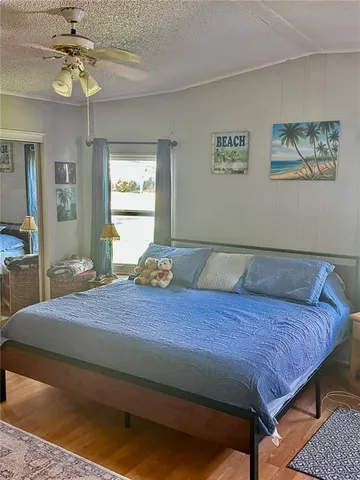 a bedroom with a bed a dresser and potted plant