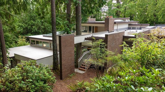 a view of a patio with table and chairs potted plants with large tree