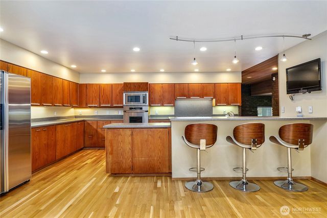a kitchen with stainless steel appliances granite countertop a sink and a refrigerator