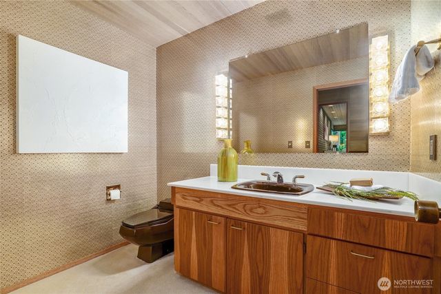 a bathroom with a granite countertop sink a toilet and mirror
