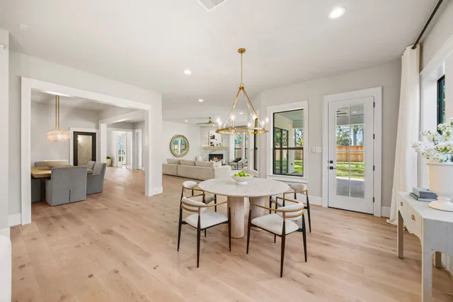 a large kitchen with a refrigerator a sink and chairs