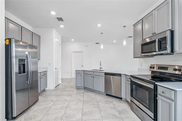 a kitchen with stainless steel appliances granite countertop a refrigerator and a stove top oven