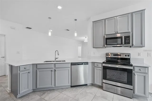 a kitchen with white cabinets stainless steel appliances and sink