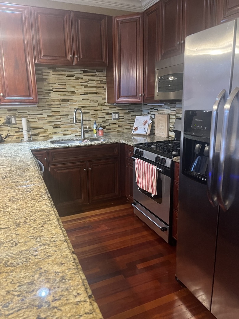 27 North Morgan Street, Unit 3 Chicago, IL 60607 - Photo 2 of 18 a kitchen with stainless steel appliances granite countertop wooden cabinets a stove top oven a sink and dishwasher