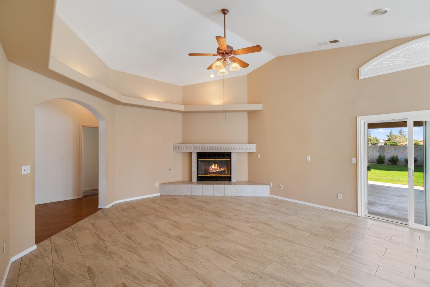 43 East Loop Madera, CA 93637 - Photo 12 of 49 a view of an empty room with a fireplace and a chandelier