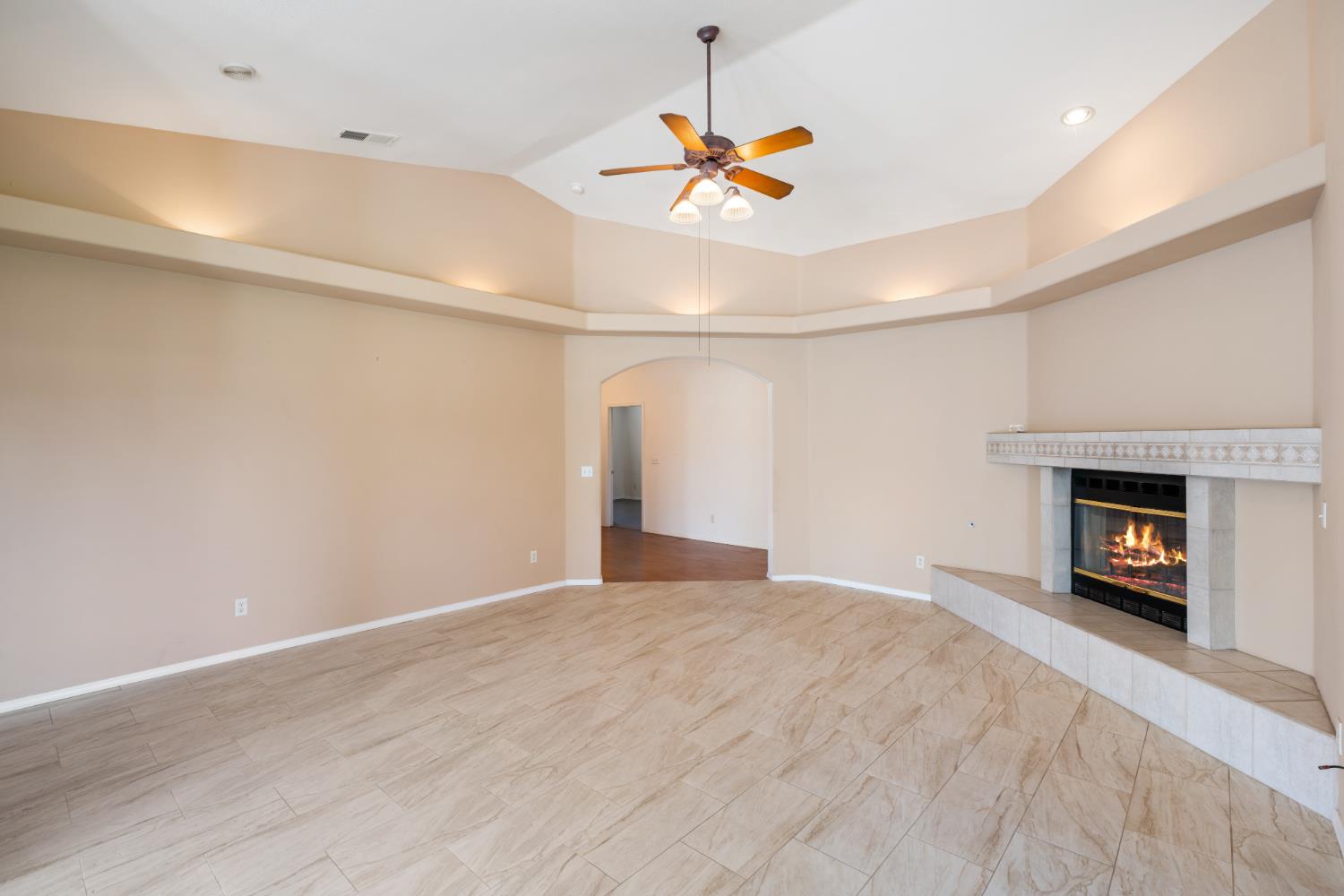43 East Loop Madera, CA 93637 - Photo 13 of 49 a view of an empty room with a fireplace and a chandelier fan