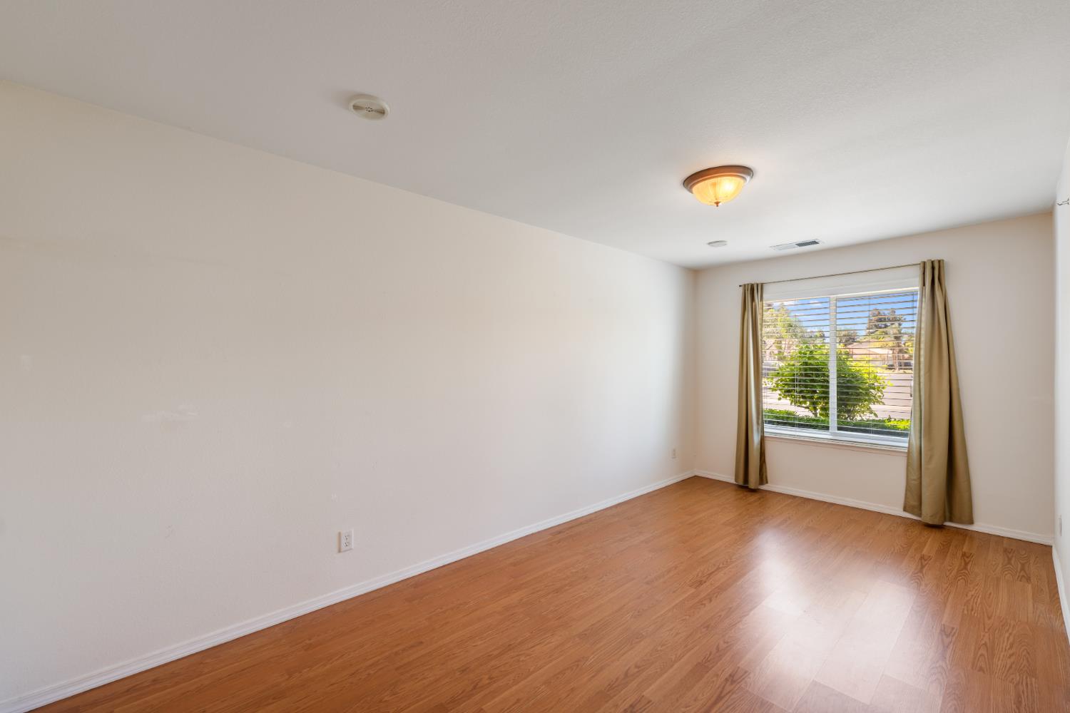 43 East Loop Madera, CA 93637 - Photo 21 of 49 a view of an empty room with wooden floor and a window