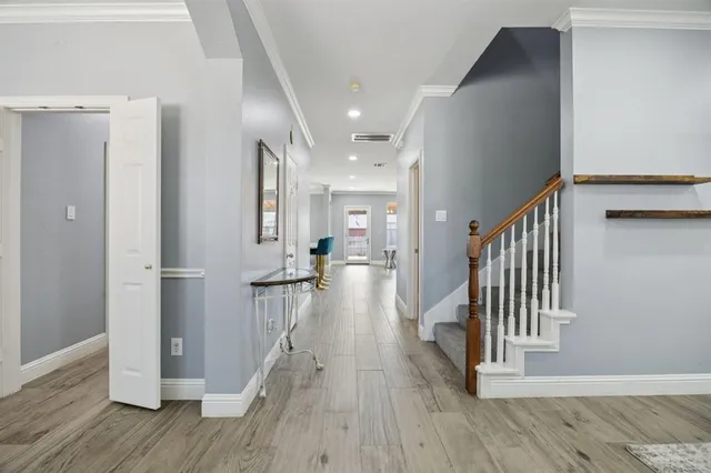 a view of a hallway with wooden floor and staircase
