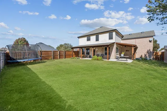 a view of a house with backyard and a sitting area