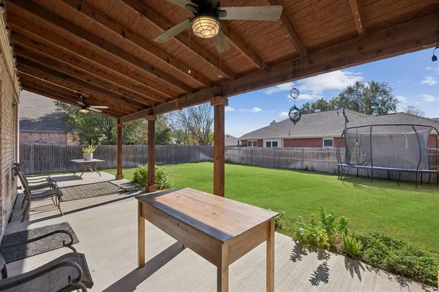 a patio with a table and chairs under an umbrella