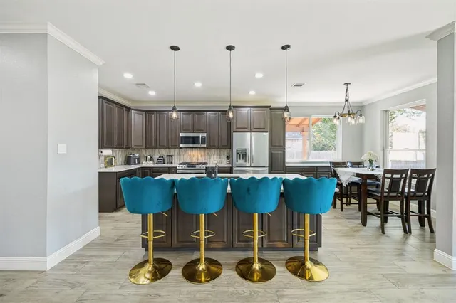 a view of kitchen with granite countertop cabinets and dining table