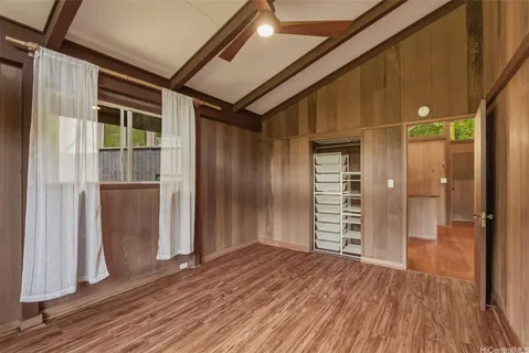 a view of a hallway with wooden floor and closet