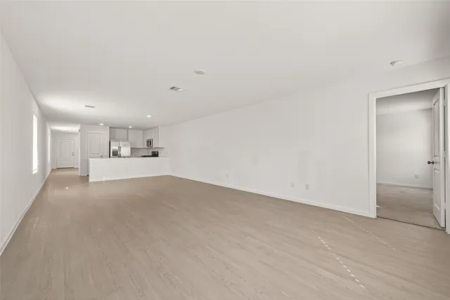 a view of a kitchen with wooden floor and cabinets