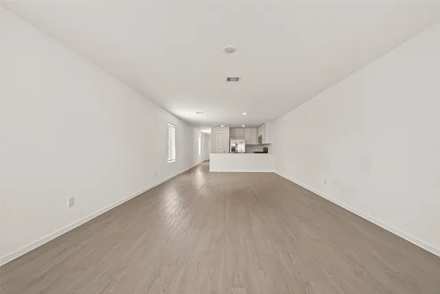 a view of a livingroom with wooden floor and windows