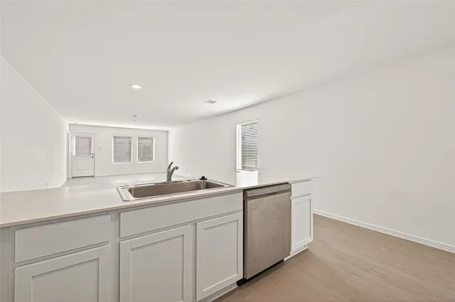 a kitchen with refrigerator cabinets and wooden floor