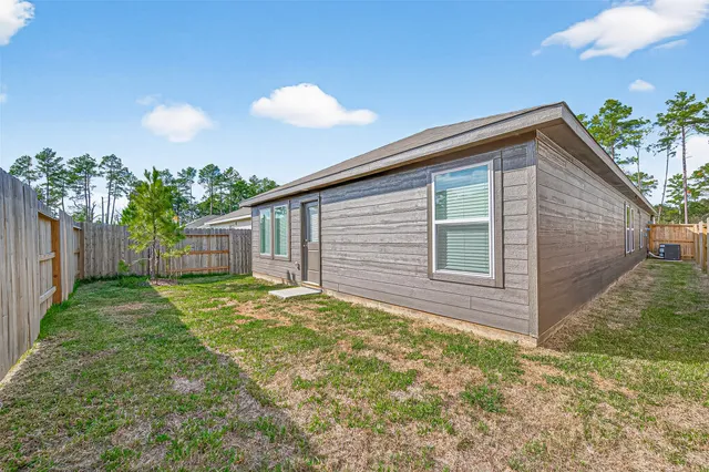 a view of backyard with wooden fence