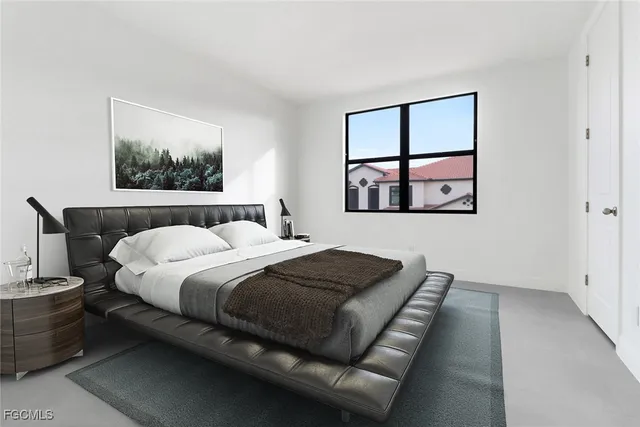 a bedroom with a bed and a painting on the wall