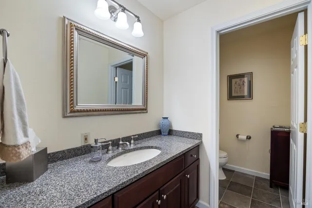 a bathroom with a granite countertop sink and a mirror