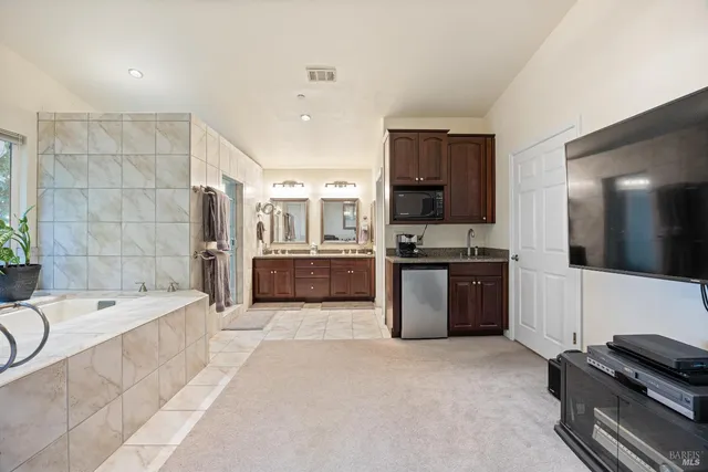 a large white kitchen with a large window and stainless steel appliances