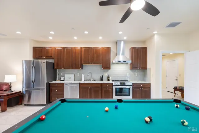 a kitchen with kitchen island stainless steel appliances a sink cabinets and wooden floor