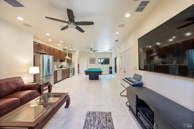 a living room with furniture and a view of kitchen