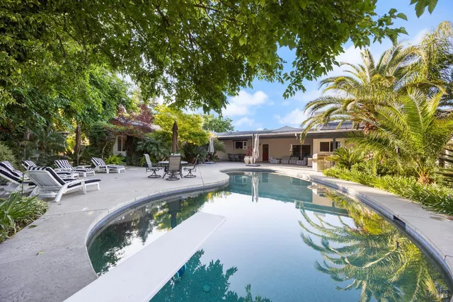 a view of a house with swimming pool and sitting area