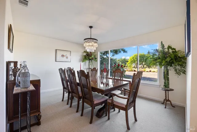 a view of a dining room with furniture and chandelier