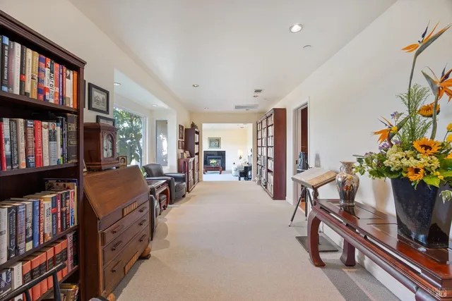 a living room with furniture a bookshelf and a window
