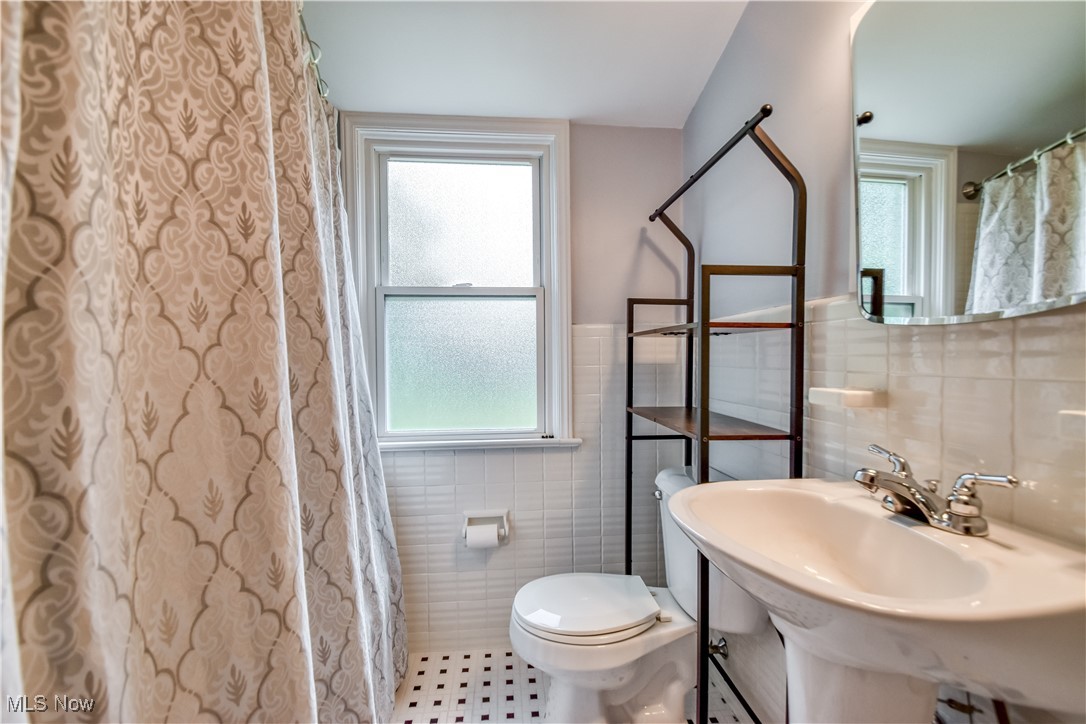 8115 Stockbridge Road Mentor, OH 44060 - Photo 24 of 46 Bathroom with tile walls, tile patterned floors, and a wainscoted wall