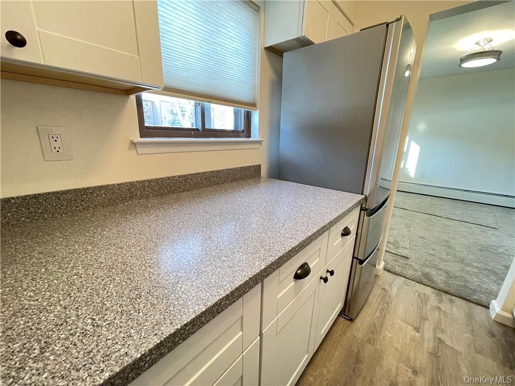 27 Tanager Road, Unit 2702 Monroe, NY 10950 - Photo 5 of 17 Kitchen featuring speckled countertops and white shaker-style cabinetry with dark hardware