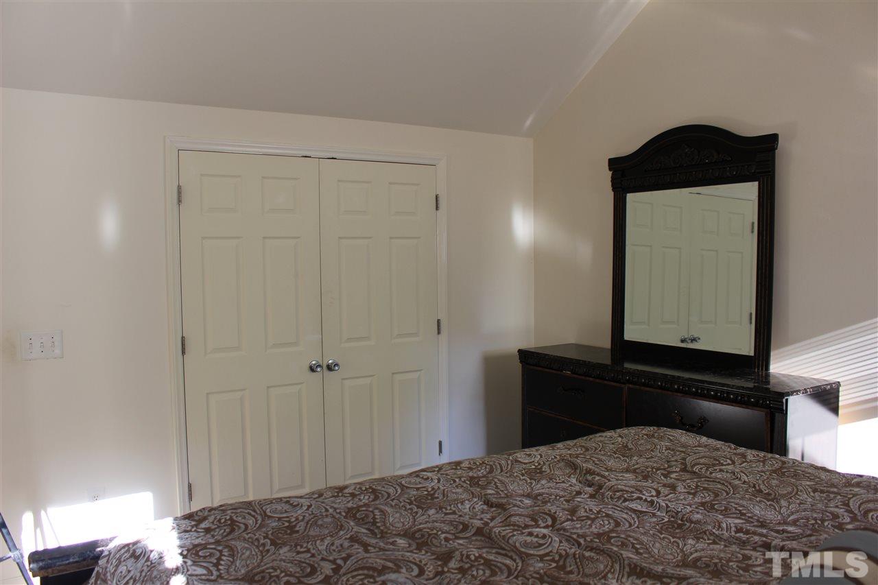 1432 Ricochet Drive Raleigh, NC 27610 - Photo 19 of 23 a bedroom with a bed and a mirror