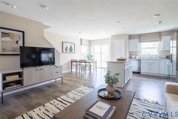 a living room with granite countertop furniture a flat screen tv and kitchen view