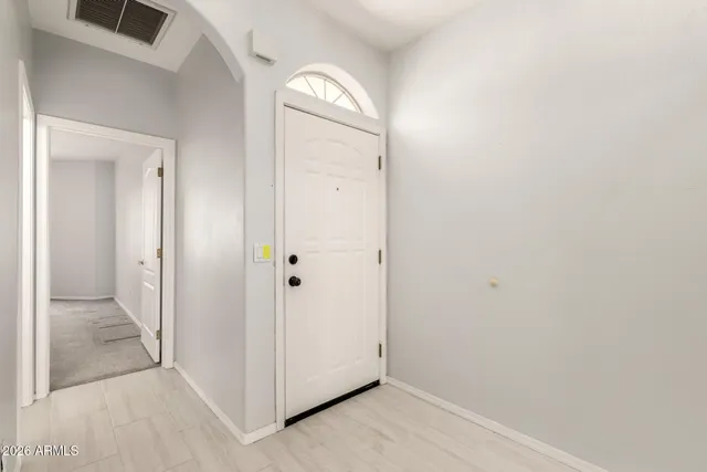 an empty room with mirror and windows