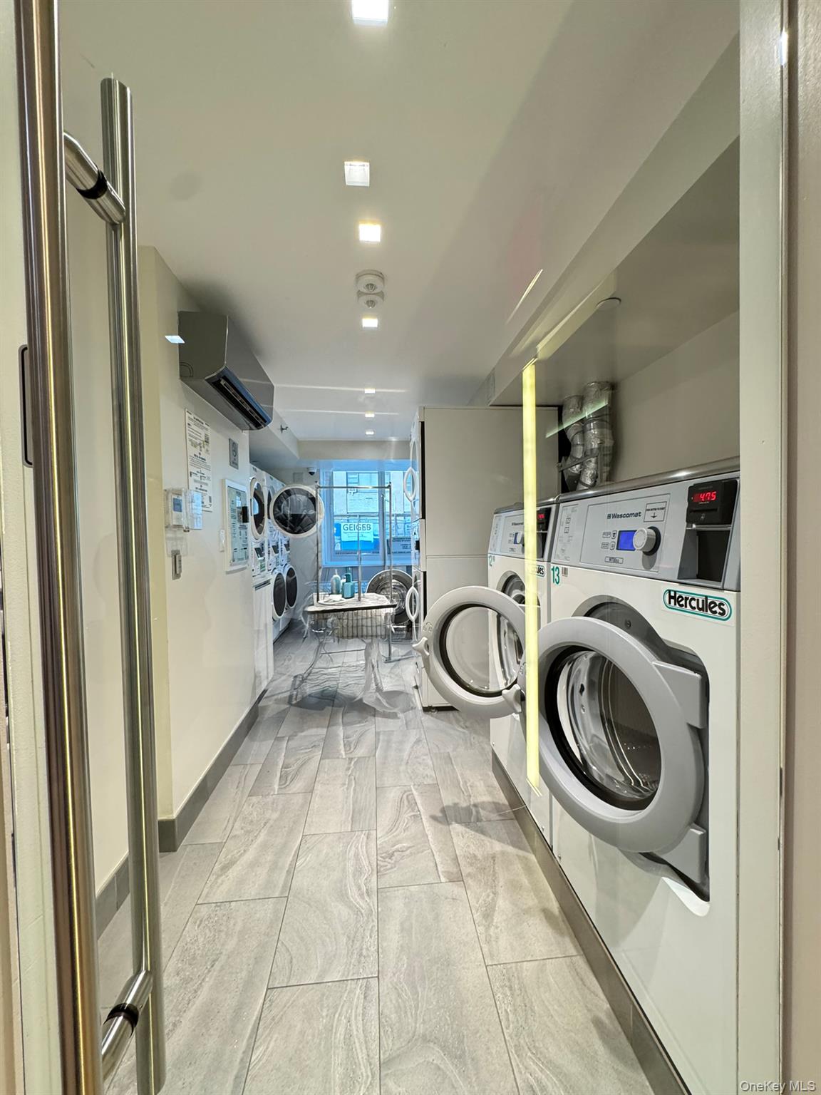 301 West 53rd Street, Unit 9K Manhattan, NY 10019 - Photo 20 of 22 Community laundry featuring independent washer and dryer and a wall unit AC