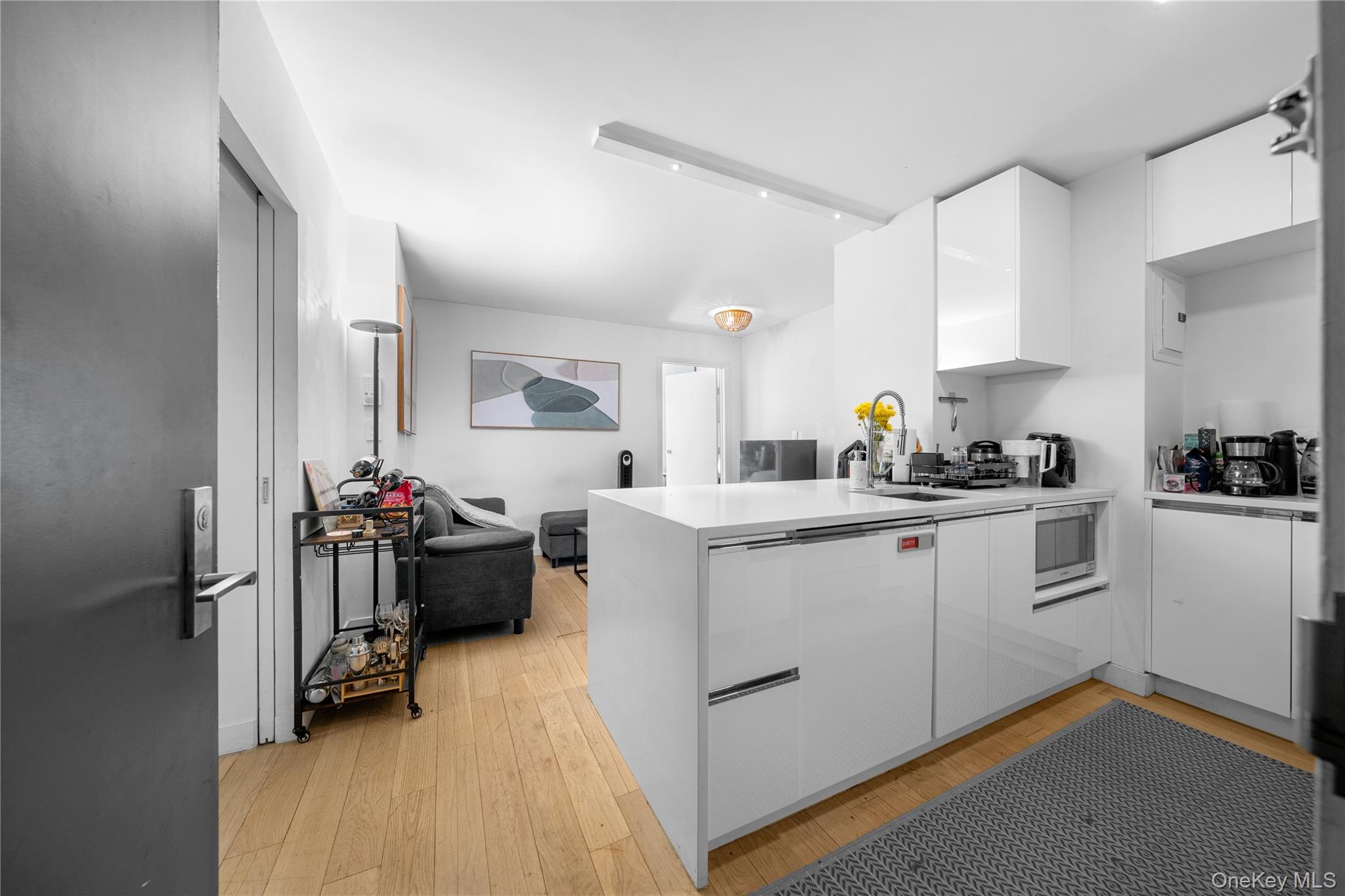 301 West 53rd Street, Unit 9K Manhattan, NY 10019 - Photo 27 of 40 a kitchen with a refrigerator and white cabinets