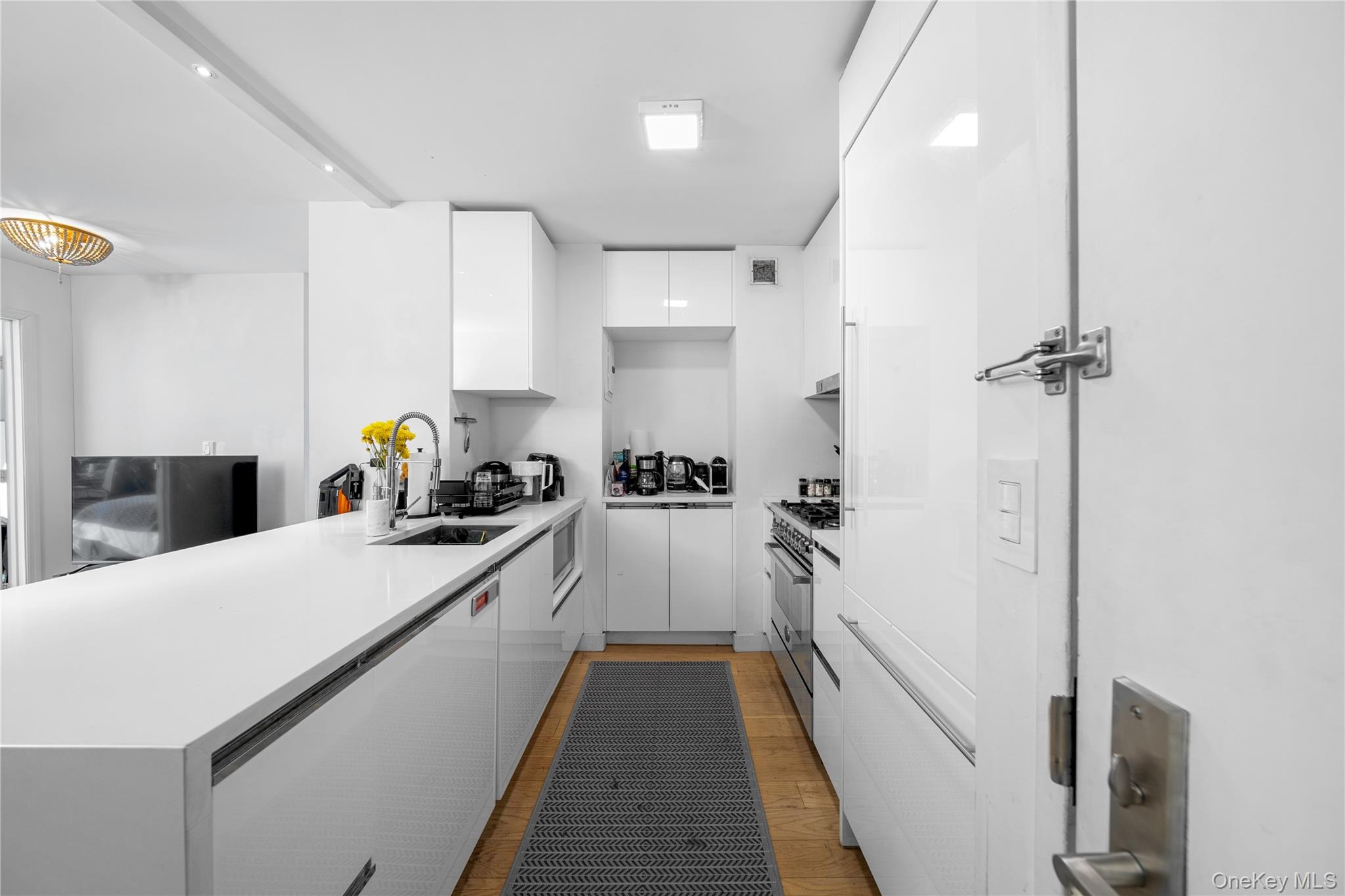 301 West 53rd Street, Unit 9K Manhattan, NY 10019 - Photo 28 of 40 a view of a kitchen with kitchen island a counter top space a sink a refrigerator and a stove