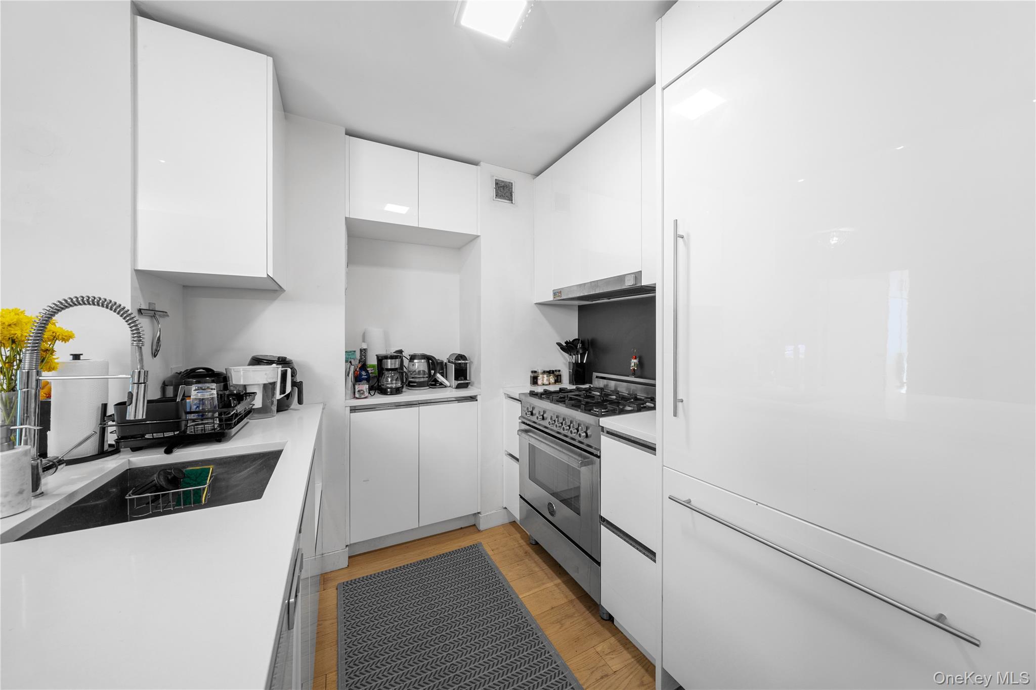 301 West 53rd Street, Unit 9K Manhattan, NY 10019 - Photo 29 of 40 a kitchen with stainless steel appliances granite countertop a sink a stove and a refrigerator