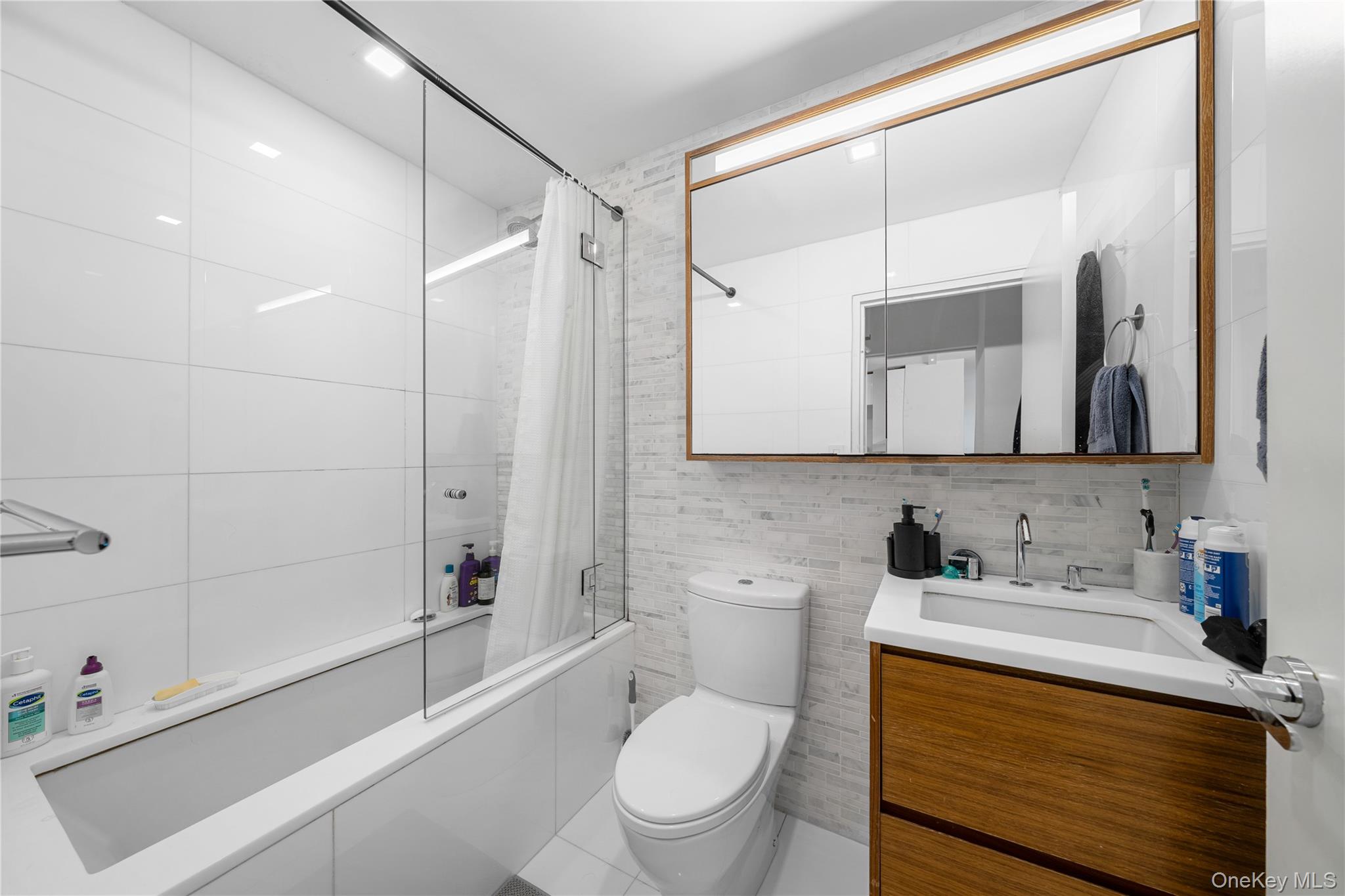 301 West 53rd Street, Unit 9K Manhattan, NY 10019 - Photo 39 of 40 a bathroom with a sink a toilet and a bathtub