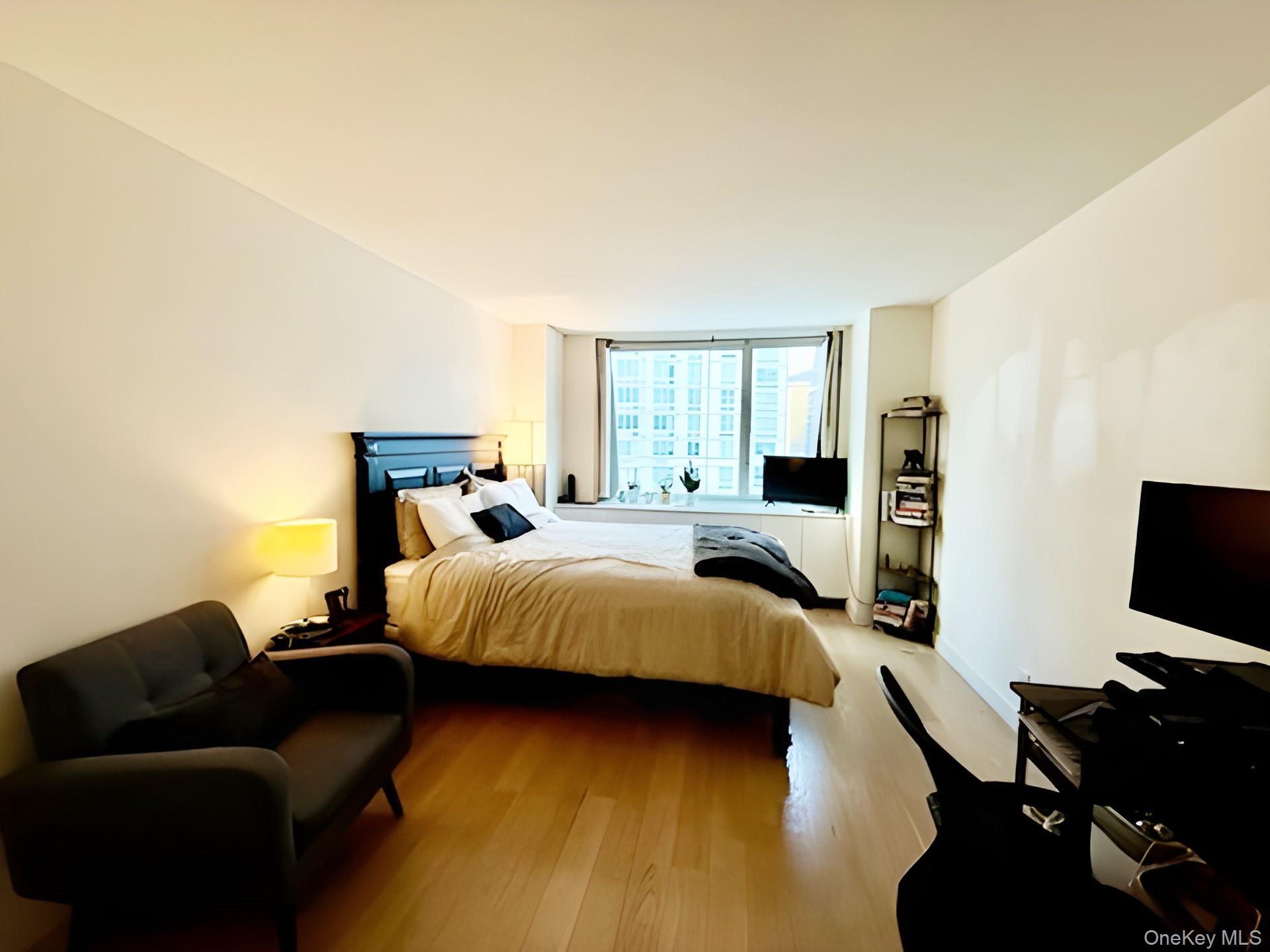 301 West 53rd Street, Unit 9K Manhattan, NY 10019 - Photo 8 of 22 Bedroom featuring wood finished floors and floor to ceiling windows