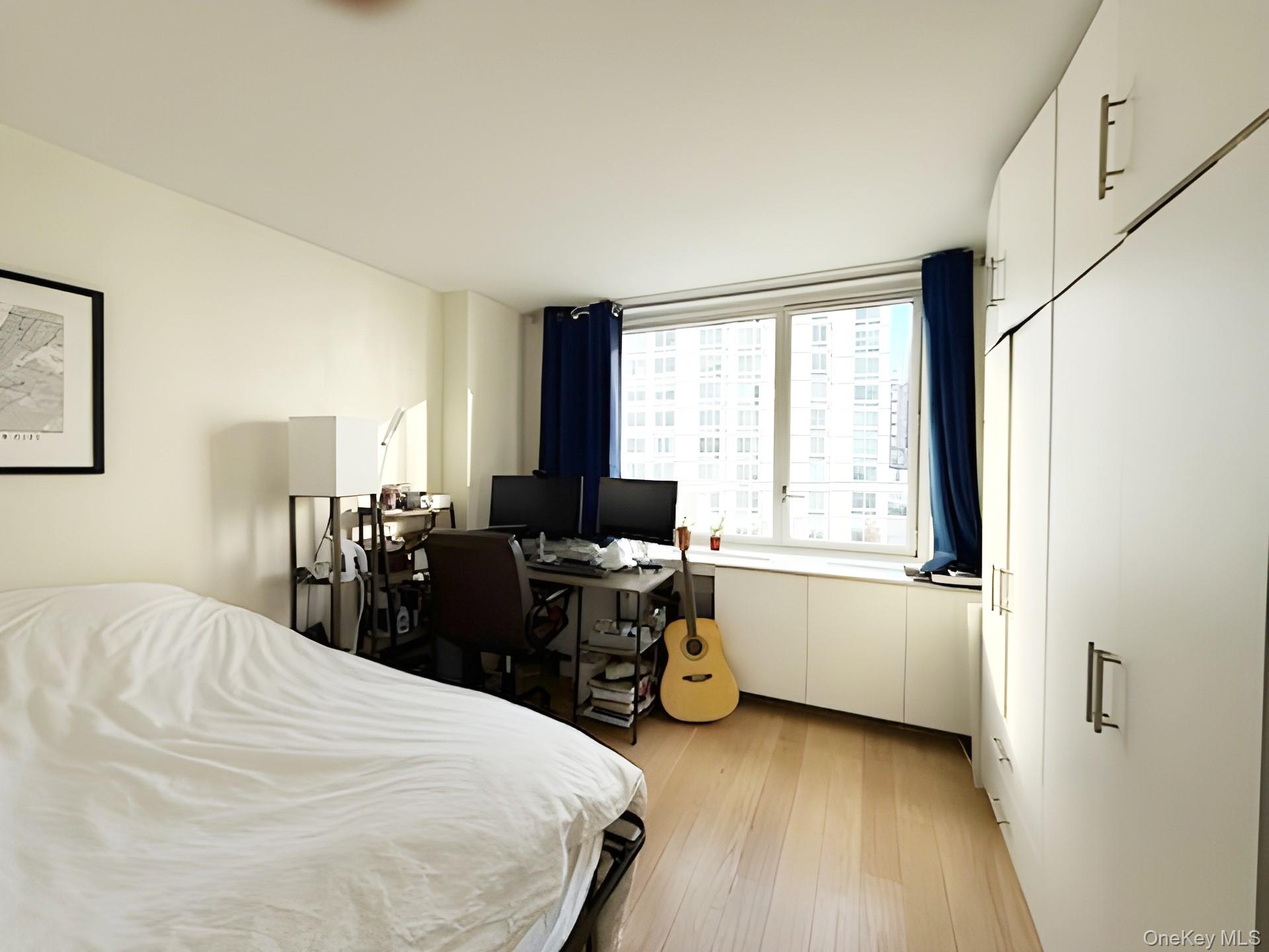 301 West 53rd Street, Unit 9K Manhattan, NY 10019 - Photo 9 of 22 Bedroom with light wood-style floors and a desk