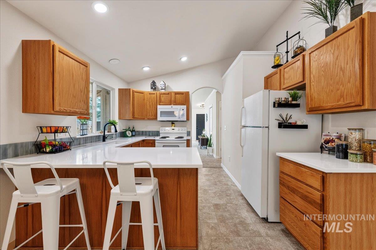 2356 West Hill Road Boise, ID 83702 - Photo 10 of 22 Kitchen featuring wood cabinetry, white countertops, built-in recessed lighting, a white electric range, and a dual-basin sink with a gooseneck faucet