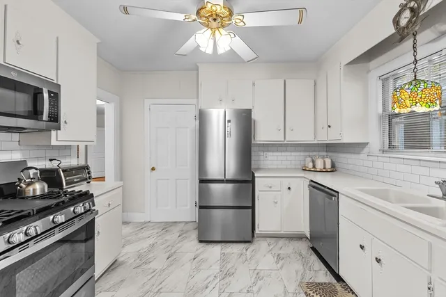 a kitchen with stainless steel appliances a stove a refrigerator and a sink