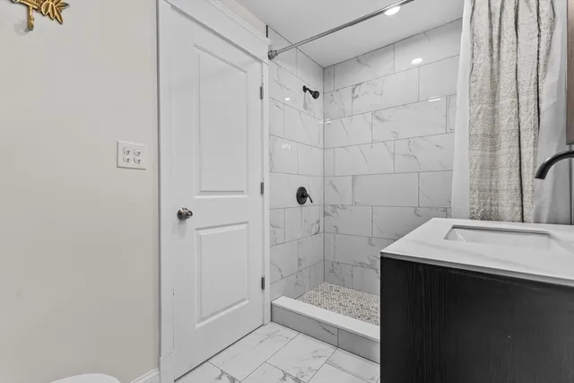 a bathroom with a sink a toilet and shower