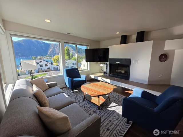 a living room with furniture a large window and a fireplace