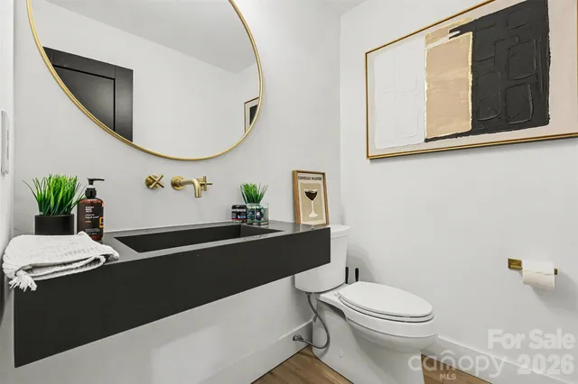 a bathroom with a sink a toilet and a mirror