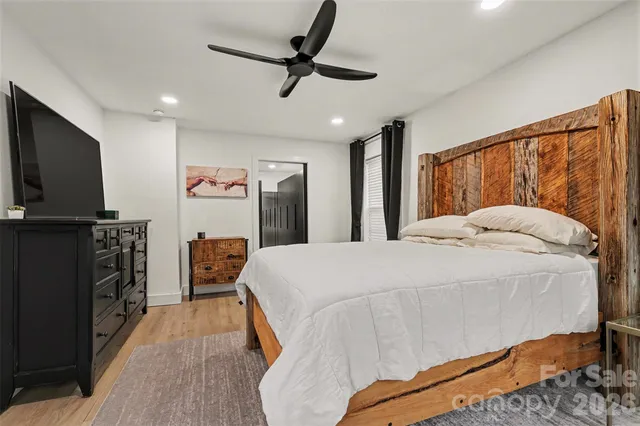 a spacious bedroom with a bed and a flat screen tv