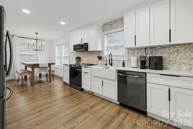 a kitchen with white cabinets sink and stainless steel appliances