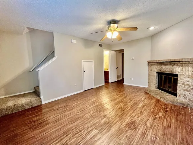 a view of empty room with wooden floor and fireplace