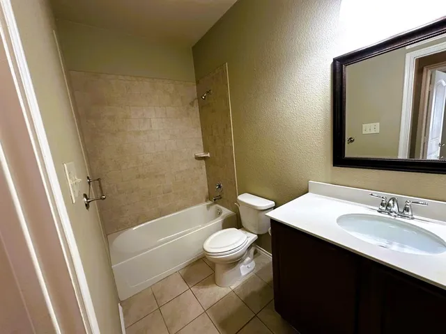 a bathroom with a sink a toilet a mirror and shower